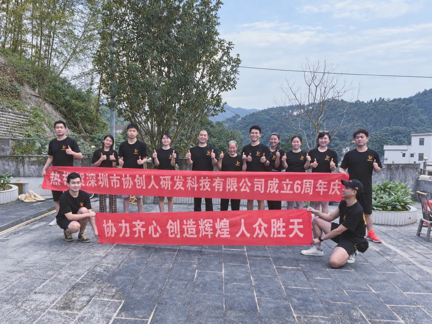 协创人成立六周年活动合影,团队在户外持周年纪念横幅